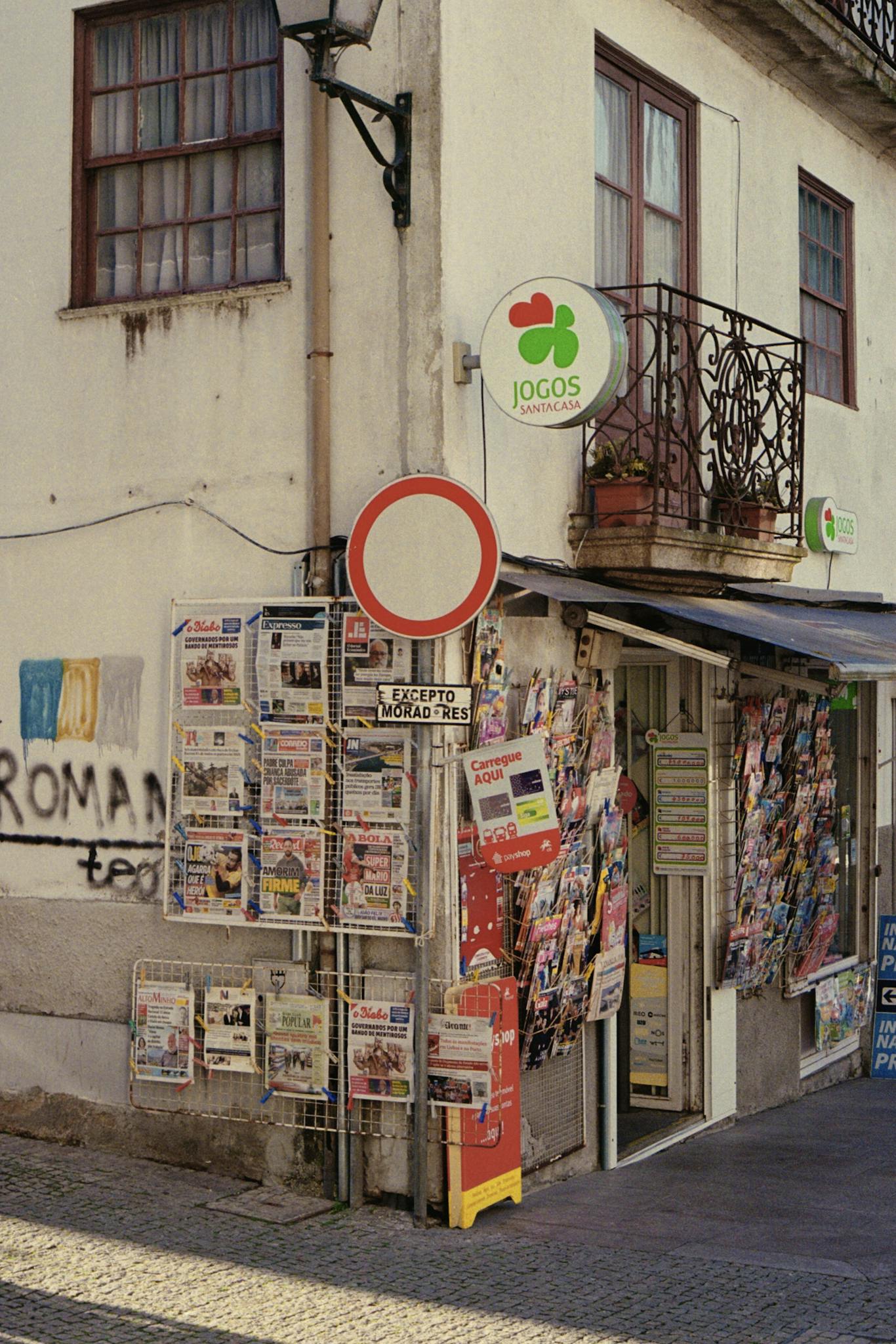 Colorful newspaper stand on a street corner in Barcelos, Portugal, showcasing local publications.