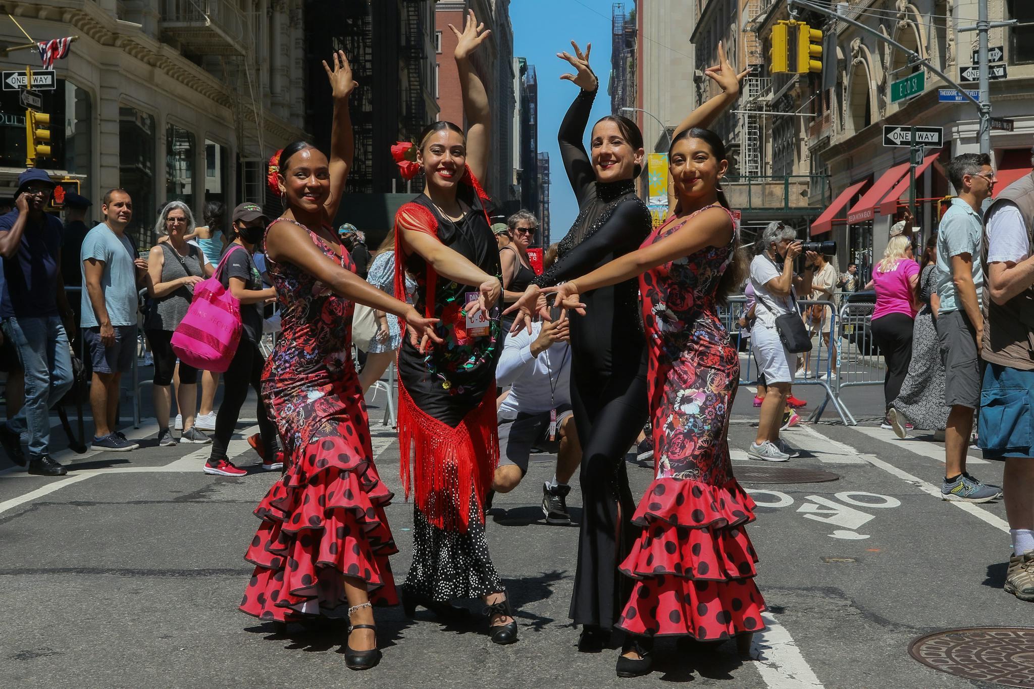 Flamenco dancers in colorful dresses performing at a street festival in New York City.