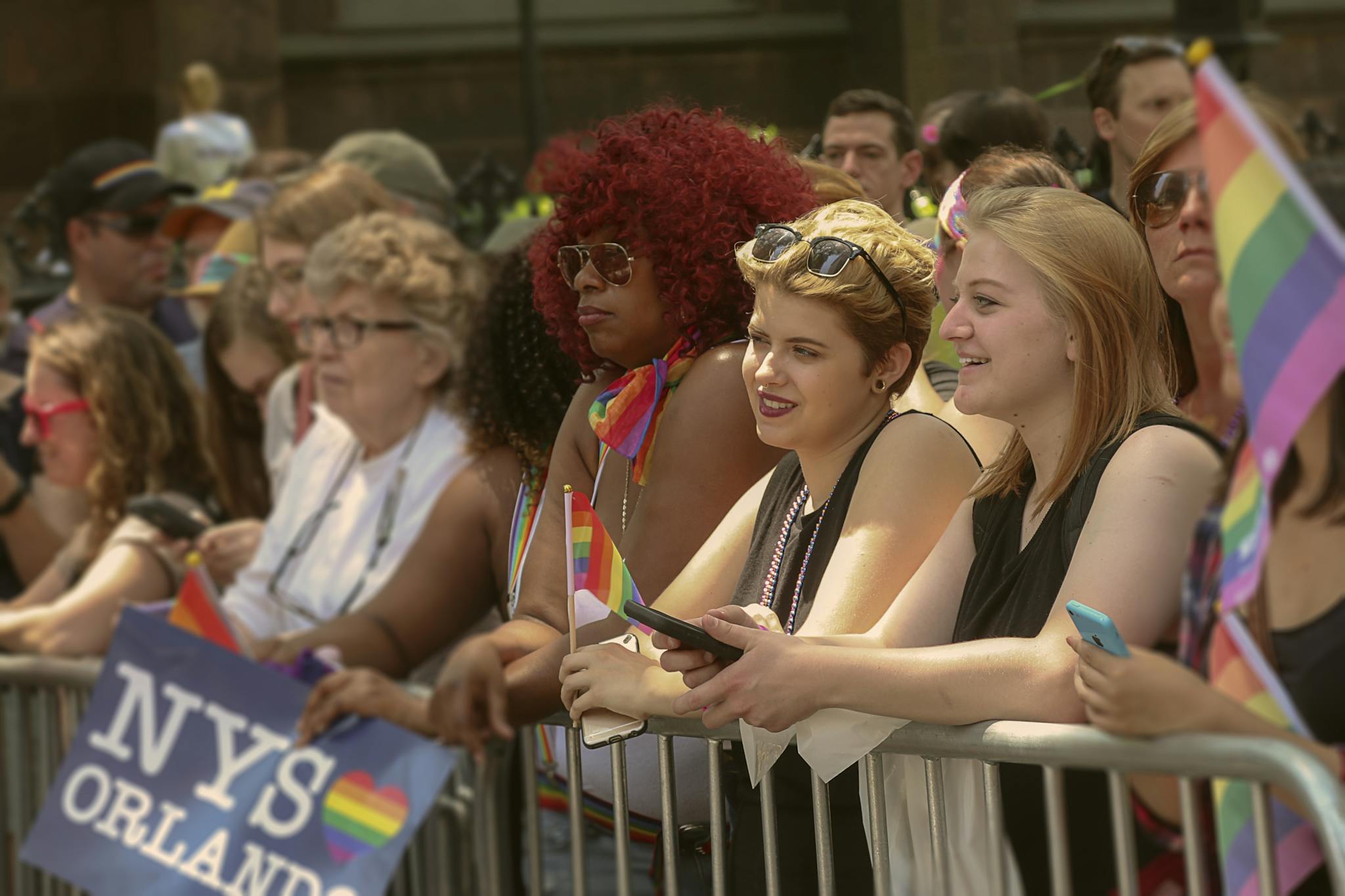Vibrant scene of people celebrating at the NYC Pride Parade, waving rainbow flags and enjoying the festivities.