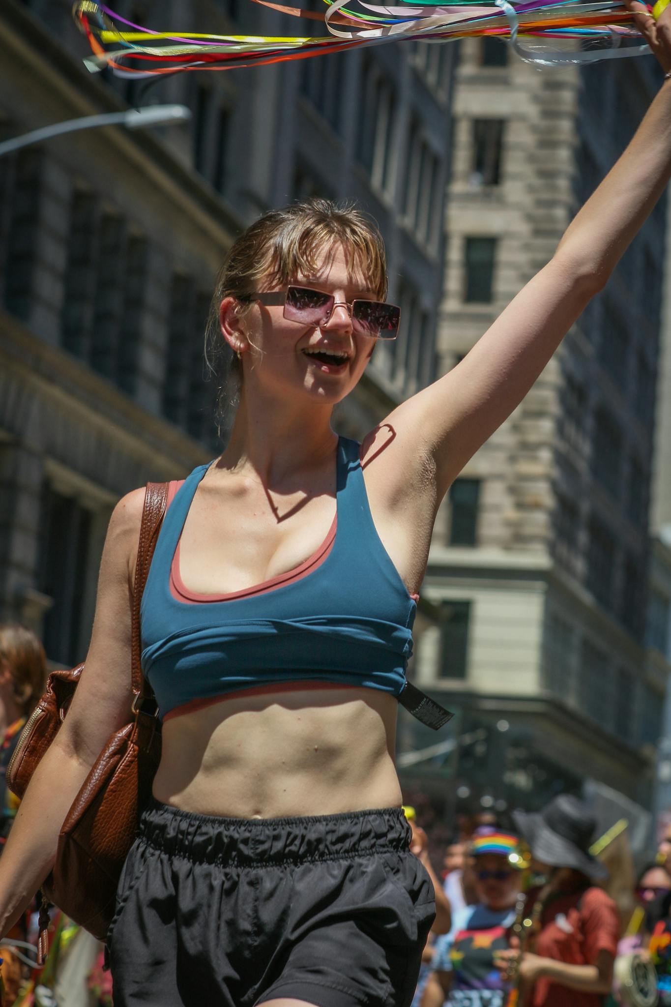 Young woman celebrating and dancing in a vibrant parade in NYC.