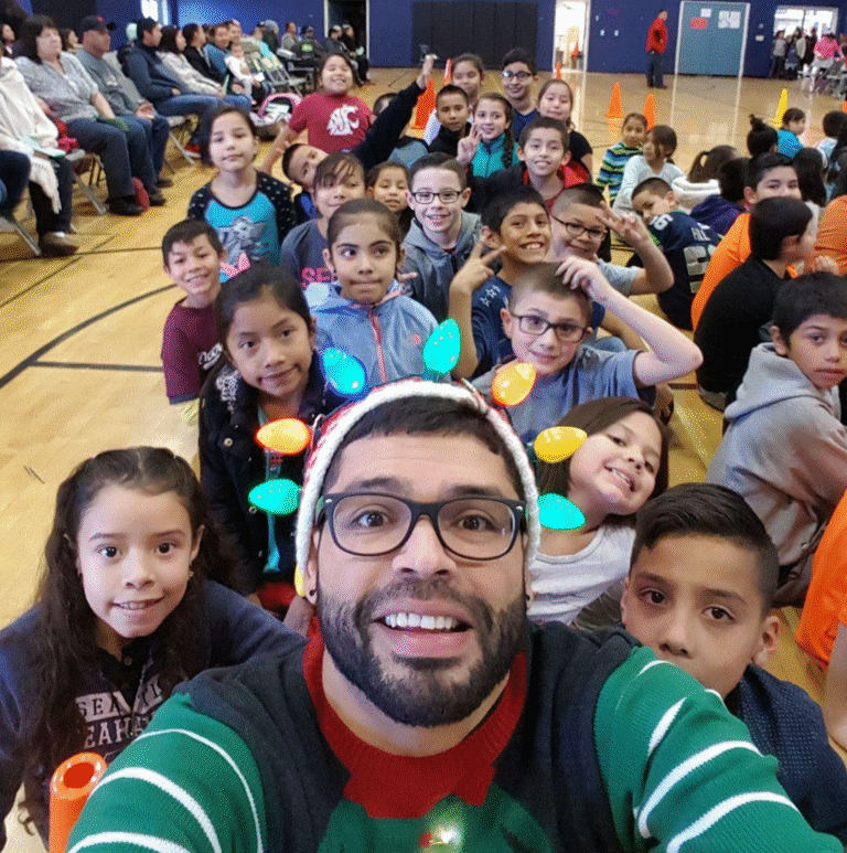 Adolph Muller se toma una selfie con sus estudiantes de primaria en Sunnyside, WA, durante un evento escolar.